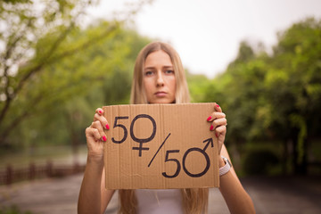 Gender equality concept as woman hands holding a paper sheet with male and female symbol over a...