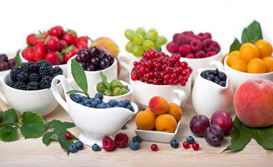 different summer berries red currant, gooseberry, raspberry in glass trays. sorted by type. superfoods from the garden