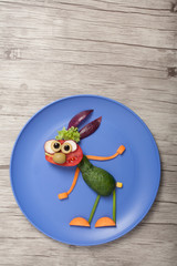 Vegetable rabbit made on blue plate and wooden board