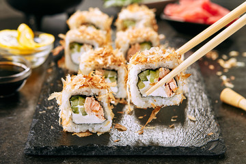 Macro Shot of Eating Katsuobushi Uramaki Sushi Rolls with Fried Salmon