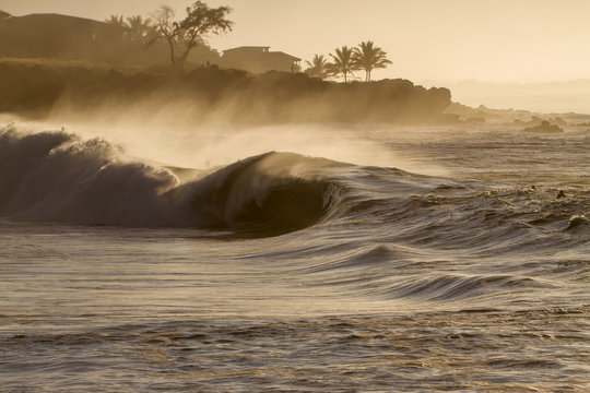 huge stormy wave crashing at sunset in hawaii
