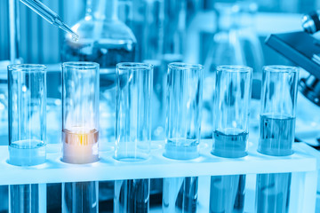scientist with equipment and science experiments, laboratory glassware containing chemical liquid for research or analyzing a sample into test tube in laboratory