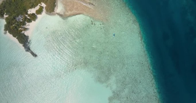 Aerial top down view of the beautiful island with turquoise tropical indian water of the ocean on the maldives. Nature paradise landscape shot.