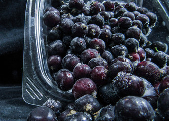black currant in the ice. frozen black currant raspberry