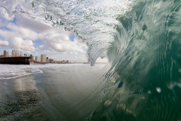 huge wave breaking with Durban City, South Africa in the background