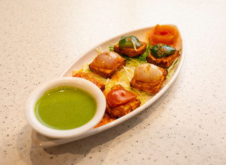 Indian Starter Dish Paneer Tikka Kabab or Paneer Cubes Made From Chunks of Cottage Cheese Marinated in Spices & Grilled in a Tandoor Served With Green Chutney