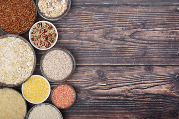 A set of bowls filled with different seeds: buckwheat, rise, corn and oatmeal	