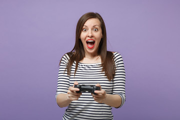 Young brunette woman girl in casual striped clothes posing isolated on violet purple background studio portrait. People sincere emotions lifestyle concept Mock up copy space Hold pc joystick play game © ViDi Studio