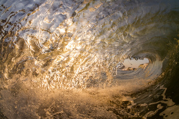 dramatic inside view of a breaking wave at sunset sunrise