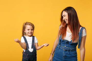 Woman in light clothes have fun with cute child baby girl 4-5 years old. Mommy little kid daughter isolated on yellow background studio portrait. Mother's Day love family parenthood childhood concept.