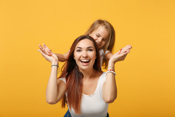 Woman in light clothes have fun with cute child baby girl 4-5 years old. Mommy little kid daughter isolated on yellow background studio portrait. Mother's Day love family parenthood childhood concept.