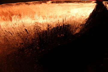 A piece of ice block, cold fire, frozen air bubbles, red ice, winter 