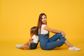 Obraz na płótnie Canvas Woman in light clothes have fun with cute child baby girl 4-5 years old. Mommy little kid daughter isolated on yellow background studio portrait. Mother's Day love family parenthood childhood concept.