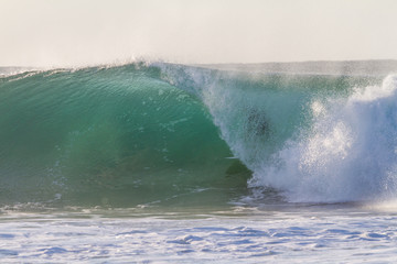 surfer getting barrelled on a huge perfect wave in the ocean