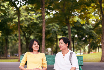 Obraz premium Portrait of middle aged asian female with daughter talking together at outdoor,Happy and smiling,Positive thinking,Take care and support concept