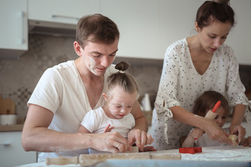 family two children preparing cookies together