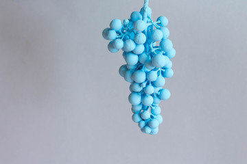 Bunch of grapes with dripping  blue paint  on grey background and copy space