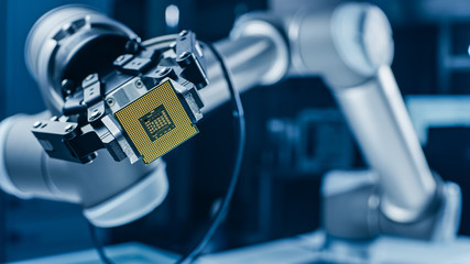 Modern High Tech Authentic Robot Arm Holding Contemporary Super Computer Processor. Industrial...