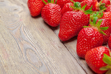 Red ripe strawberries on wooden table close up