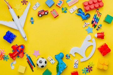 Frame of kids toys on yellow background