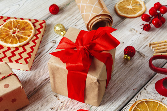  wrapping gift boxes with equipment and decorating items on wooden background
