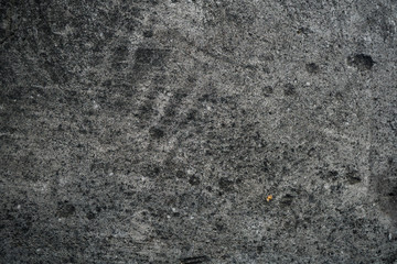 Texture of an old cracked concrete wall. Background image of a worn gray concrete surface