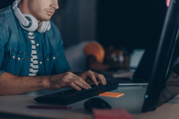 cropped view of young programmer working near african american colleague sleeping at workplace