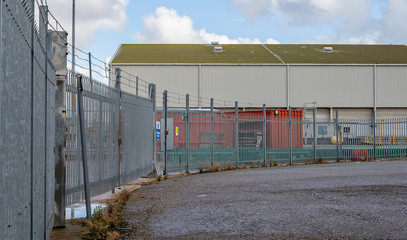 Great Yarmouth, Norfolk, UK – September 08 2019. An industrial warehouse, metal railings and security fence in the Southtown Road area of Great Yarmouth