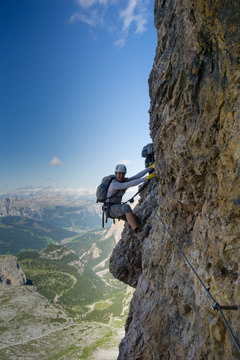attractive female climber on a steep Via Ferrata in the Italian Dolomites © makasana photo