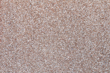 Textured wall made of small colored stones. Abstract rough grunge modern background
