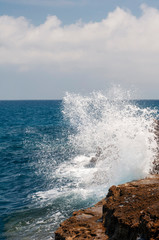 Fototapeta na wymiar waves crashing on the rocks in Italy