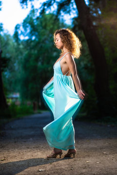 Beautiful fashion model woman dancing in the forest during sunset