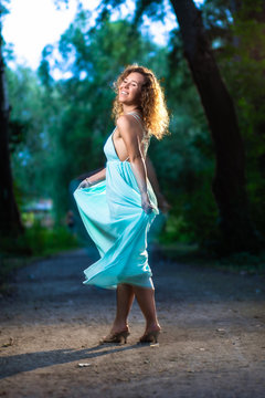 Beautiful fashion model woman dancing in the forest during sunset