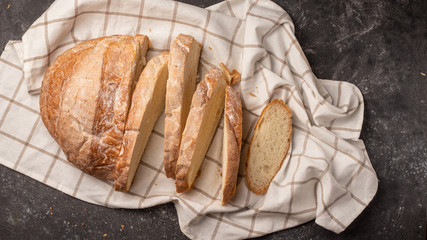 round bread cut into many pieces, located with a white checkered napkin on a black background