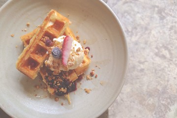 Waffle and vanilla ice cream with strawberry And blueberry on ceramic plate