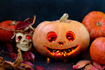 Halloween Creative composition with a skull and a Scary pumpkin on dark background, close up,...