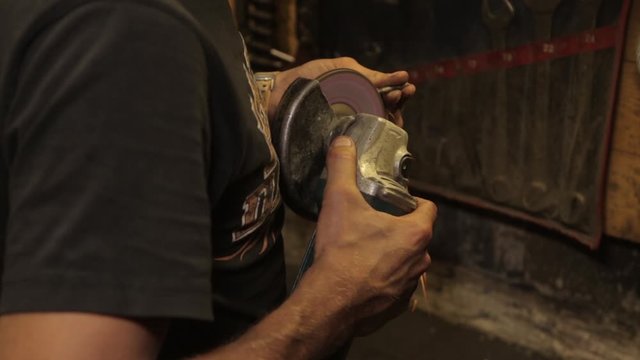 mechanical assembly fitter work with angle grinder hands close up  - video