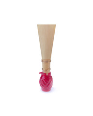 Double reed for bassoon with red thread on a white background. Tongue mouthpiece for wind musical instruments. With a slight shadow.