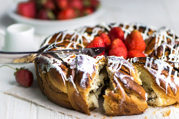 round cupcake with white filling, poppy seeds and strawberries on a wooden background
