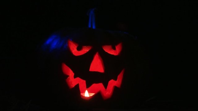 Creepy halloween pumpkin lantern against a black background