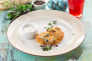 chicken fillet baked with melted cheese and white sauce on blue wooden table