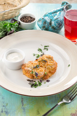 chicken fillet baked with melted cheese and white sauce on blue wooden table