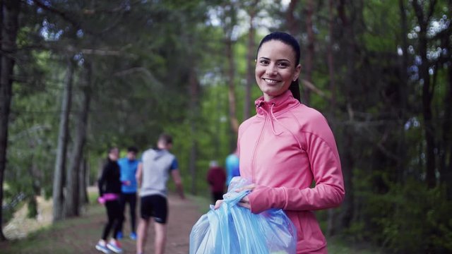 Group of fit people picking up litter in nature, a plogging concept.