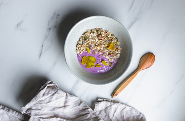 healthy breakfast, a bowl with organic granola, chocolate pieces and vegan soya yogurt on marble background with copy space