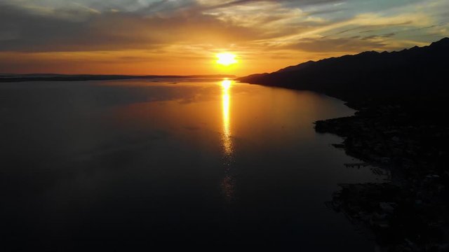 Upwards Aerial Drone Shot of Sun Setting Over the Calm Ocean