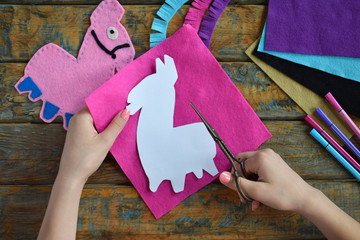 Making pink lama. Sewing toys from felt with your own hands. DIY concept for children. Handmade...