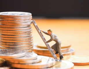 Pile of coins. miniature man climbing up with ladder , Business and investment concept..