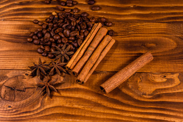 Pile of the coffee beans, star anise and cinnamon sticks on wooden table