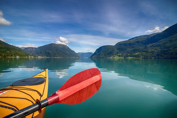 kayaking on the fjord, yellow kayak red paddle, boat