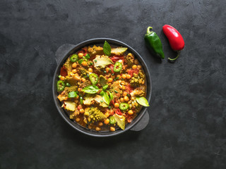 Nutty roasted romanesco curry in a black background. Top view. 
